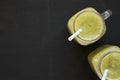 Homemade green cucumber apple smoothie in glass jars on a black background, top view. Flat lay, overhead, from above. Copy space Royalty Free Stock Photo