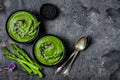 Homemade green spring asparagus cream soup decorated with black sesame seeds and edible chives flowers. Royalty Free Stock Photo