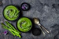 Homemade green spring asparagus cream soup decorated with black sesame seeds and edible chives flowers. Royalty Free Stock Photo