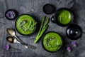 Homemade green spring asparagus cream soup decorated with black sesame seeds and edible chives flowers. Royalty Free Stock Photo