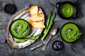Homemade green spring asparagus cream soup decorated with black sesame seeds and edible chives flowers. Royalty Free Stock Photo