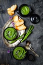 Homemade green spring asparagus cream soup decorated with black sesame seeds and edible chives flowers. Royalty Free Stock Photo