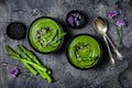 Homemade green spring asparagus cream soup decorated with black sesame seeds and edible chives flowers. Royalty Free Stock Photo