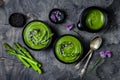 Homemade green spring asparagus cream soup decorated with black sesame seeds and edible chives flowers. Royalty Free Stock Photo