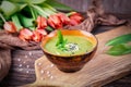 Homemade green spring cream soup with wild leek on a wooden background. Red orange tulips flowers Royalty Free Stock Photo