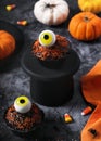 Homemade Halloween chocolate cupcakes with yellow jelly eyeballs decorated with sprinkles, candy and pumpkins. Royalty Free Stock Photo