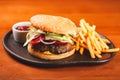 Homemade hamburger and french fries on black plate Royalty Free Stock Photo