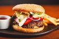 Homemade hamburger and french fries on black plate. Royalty Free Stock Photo
