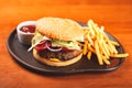 Homemade hamburger and french fries on black plate Royalty Free Stock Photo