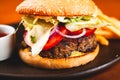 Homemade hamburger and french fries on black plate. Royalty Free Stock Photo