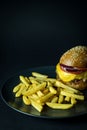 Homemade hamburger with french fries on plate isolated on black with copy space Royalty Free Stock Photo