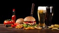 Homemade hamburger with french fries and two glasses of beer on wooden table. In the burger stuck a knife Royalty Free Stock Photo