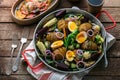 Homemade Hasselback Potatoes in a pat with root vegetables. Royalty Free Stock Photo