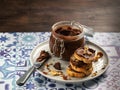 Homemade hazelnut cream in bowl with hazelnut nuts and slices of toast with chocolate cream on wooden background with copy space