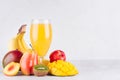 Homemade healthy beverage - multi fruits juice of red, yellow, green, orange fruits on soft light white wood background.