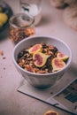 Homemade healthy granola with fresh figs and honey drizzle in a breakfast bowl on pink table Royalty Free Stock Photo