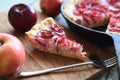 Homemade healthy sweets. Piece of apple rose pie on wooden cutting board served with organic apples Royalty Free Stock Photo
