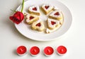 Homemade Heart shaped Almond Linzer cookies on white plate. Romantic set up red roses and candle lights ffor anniversary Royalty Free Stock Photo
