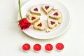 Homemade Heart shaped Almond Linzer cookies on white plate. Romantic set up red roses and candle lights ffor anniversary Royalty Free Stock Photo