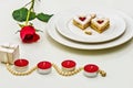 Homemade Heart shaped Almond Linzer cookies on white plate. Romantic set up red roses and candle lights ffor anniversary Royalty Free Stock Photo