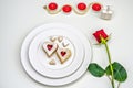 Homemade Heart shaped Almond Linzer cookies on white plate. Romantic set up red roses and candle lights ffor anniversary Royalty Free Stock Photo