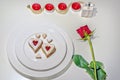 Homemade Heart shaped Almond Linzer cookies on white plate. Romantic set up red roses and candle lights ffor anniversary Royalty Free Stock Photo