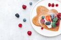Homemade heart shaped pancakes with berries.