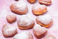 Homemade heart sheped donuts with powdered sugar on pnk background. Royalty Free Stock Photo