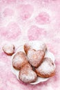 Homemade heart sheped donuts with powdered sugar on pnk background. Royalty Free Stock Photo