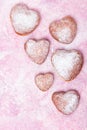 Homemade heart sheped donuts with powdered sugar on pnk background. Royalty Free Stock Photo