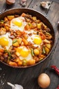 Homemade Hearty Breakfast Skillet with Eggs Potatoes and minced meat on wooden table Royalty Free Stock Photo