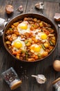 Homemade Hearty Breakfast Skillet with Eggs Potatoes and minced meat on wooden table Royalty Free Stock Photo