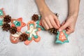 Homemade home decoration for Christmas. Children`s hands are holding a homemade garland. Gingerbread men are made of salted dough