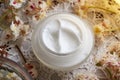 Homemade horse chestnut cream in a glass jar on a table with freh Aesculus hippocastanum flowers