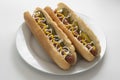 Homemade hot dogs with sausages and pickled cucubers in plate, isolated. White background