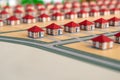 Homemade houses with red roofs made of paper are in a row. Abstract model of a village or city district. The project of a new Royalty Free Stock Photo