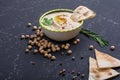 Homemade hummus, chickpea beans, rosemary with pita on black stone table. Middle Eastern traditional and authentic arab cuisine