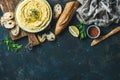 Homemade hummus dip with fresh baguette, lemon, herbs and spices