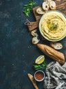 Homemade hummus dip with fresh baguette, lemon, herbs and spices