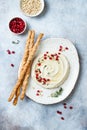 Homemade hummus with pomegranate, thyme, olive oil and pine nuts with grissini bread sticks. Middle Eastern traditional cuisine