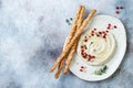 Homemade hummus with pomegranate, thyme, olive oil and pine nuts with grissini bread sticks. Middle Eastern traditional cuisine