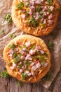 Homemade Hungarian langos with ham and cheese close-up. Vertical