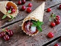 Homemade ice cream cherries and chocolate in a waffle cone, fresh cherries on old wooden table Royalty Free Stock Photo