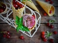 Homemade ice cream cherries and chocolate in a waffle cone, fresh cherries on old wooden table Royalty Free Stock Photo