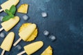 Homemade ice cream or popsicles from pineapple decorated with mint leaf. Top view. Frozen fruit pulp. Summer healthy sweets.