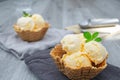 Homemade Ice cream scoops with vanilla ice cream in a bowl with mint leaf