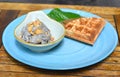 Homemade ice cream with waffle on a blue plate isolated on wooden table Royalty Free Stock Photo