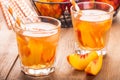 Homemade ice tea with peach slices in glasses with straws