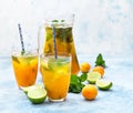 Homemade iced lemonade or tea with ripe apricot, lime and fresh mint. Fresh apricot mocktail in a jug and glasses on blue Royalty Free Stock Photo