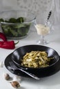 Homemade Italian fettuccine pasta. Pasta with tuna and vegetable sauce. Served in a black plate on a white table. Royalty Free Stock Photo